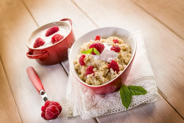 Gachas de avena con cuchara de taza de frambuesa