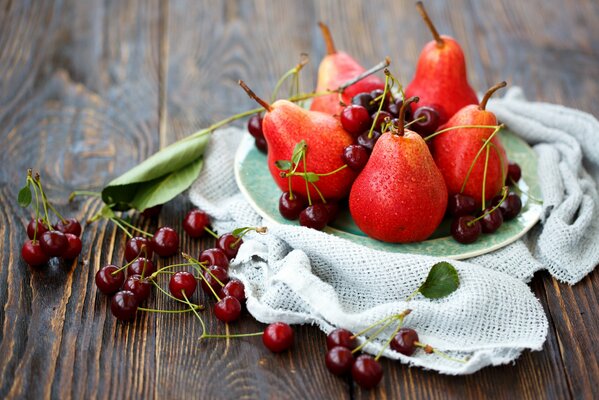 Nature morte de cerises et de poires sur fond en bois