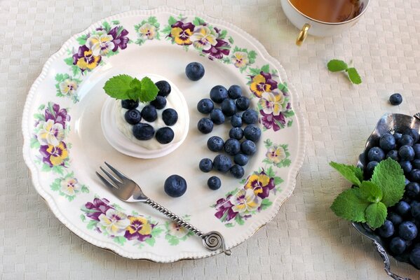 Baiser mit Blaubeerbeeren auf einem Teller