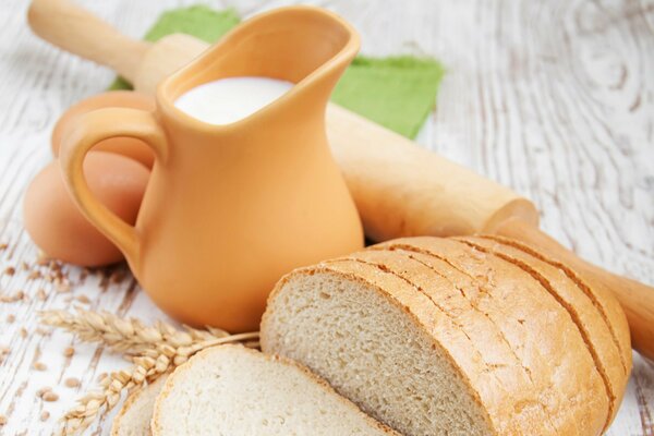 Oeufs cruche lait pain et rouleau à pâtisserie sur la table