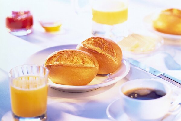 Süße Brötchen mit Kaffee zum Frühstück und Saft