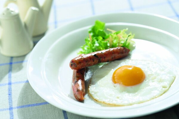 Delicious and invigorating breakfast with scrambled eggs and sausages