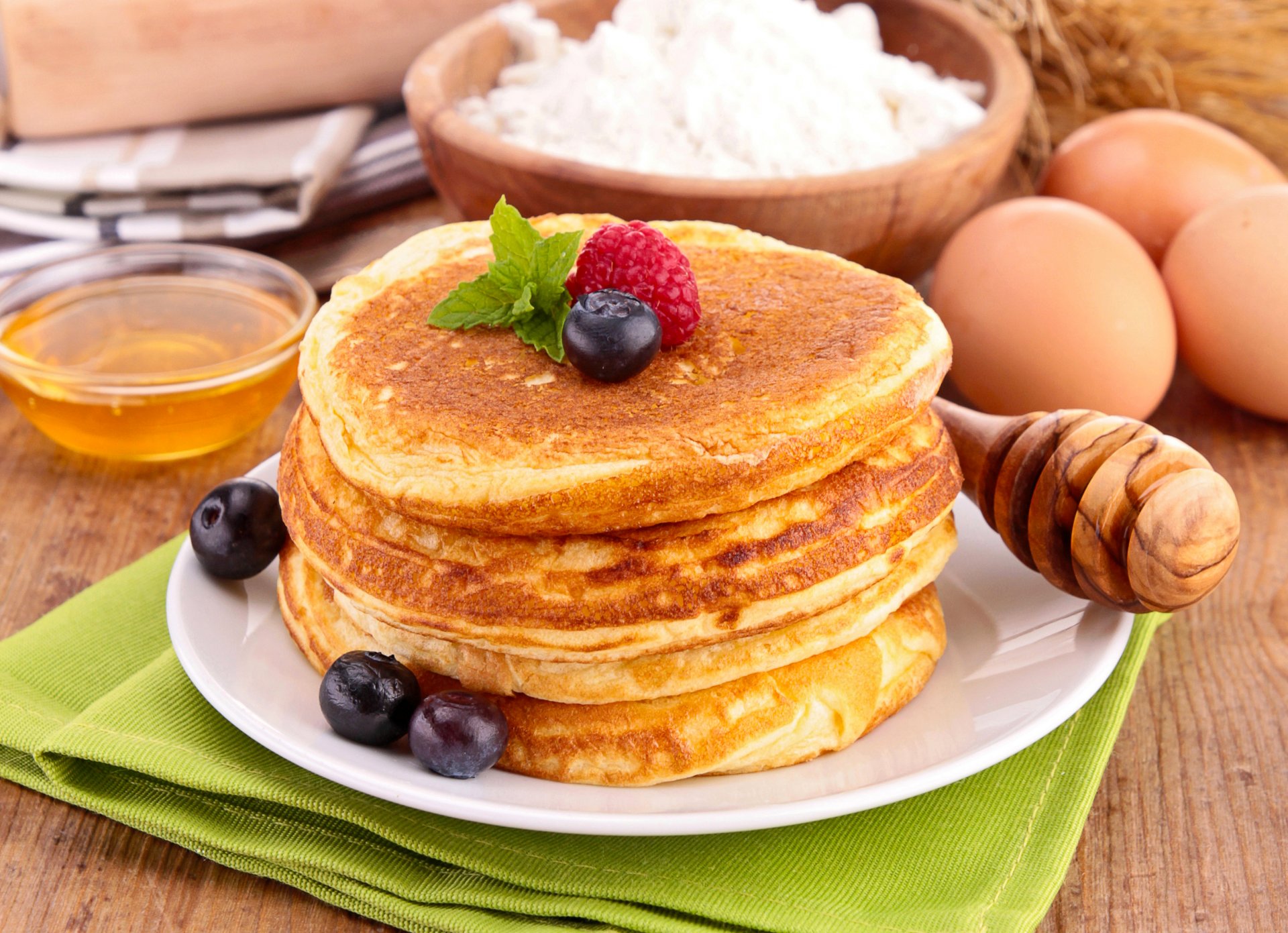 panqueques panqueques buñuelos miel frambuesas arándanos bayas vajilla cuchara harina comida