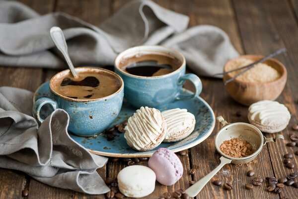 Macaroon cake with cups of coffee