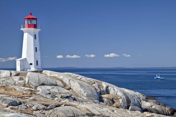 Phare et pierres sur fond de ciel et de mer