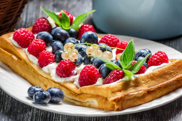 Pastel en un plato con bayas y menta