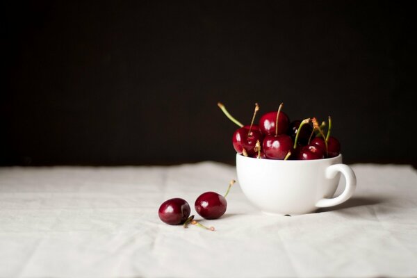 Cereza en la mesa en una taza blanca