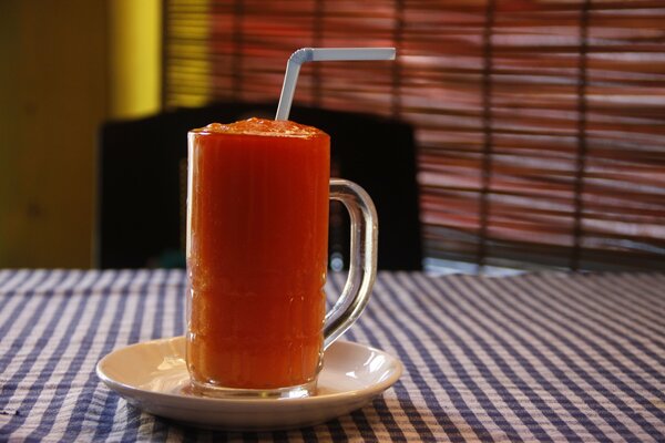 A tube sticks out in a glass of juice