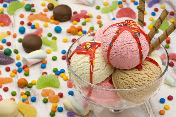 Deser lody w szklance na tle kolorowych cukierków