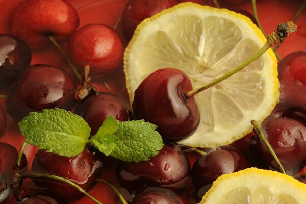 La composición de cereza y limón se complementa con una hoja de menta