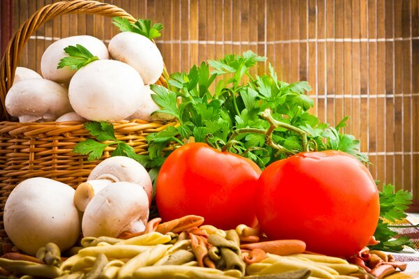 A basket with mushrooms and tomatoes next to it