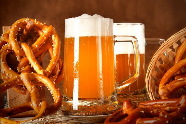 Boccale di birra dorata e snack nelle vicinanze