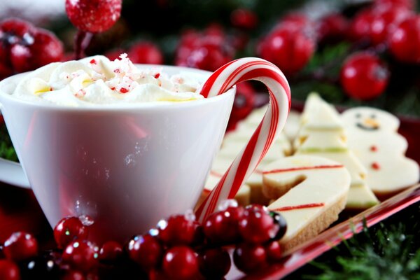 Taza de bebida caliente con bastones de caramelo