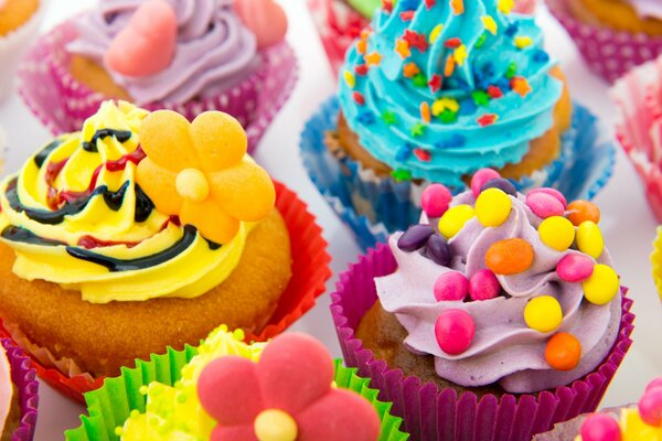 Cupcakes colorés avec de la crème brillante et des pépites