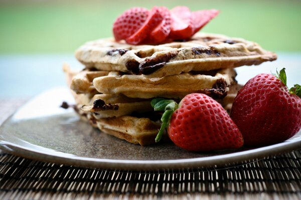 On the background of Delicious waffles with strawberries