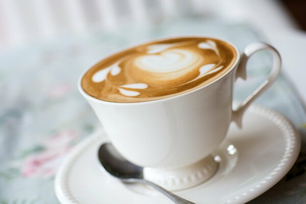 Modello su cappuccino in tazza e piattino