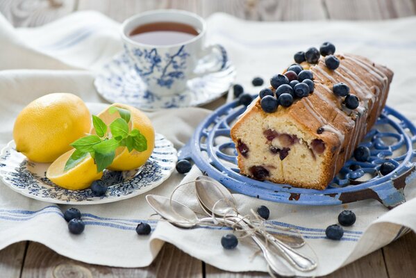 Süßer Kuchen mit Blaubeeren zum Nachtisch und einem Teller mit Zitrone