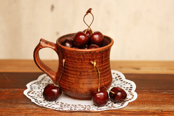 Cerezas dulces en una taza marrón en una servilleta