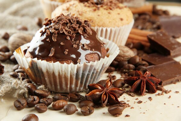 Muffins de chocolate sobre el fondo de los granos de café