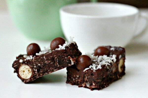 A cup of tea with two pieces of chocolate cakes