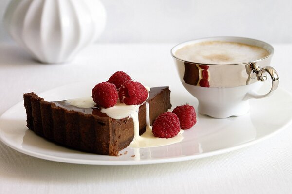 A cup of coffee and dessert with raspberries