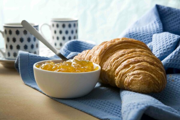 Petit-déjeuner avec croissant et kebab sucré sur soucoupe