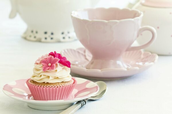 Ein Kuchen mit Sahne ist mit rosa Blüten verziert