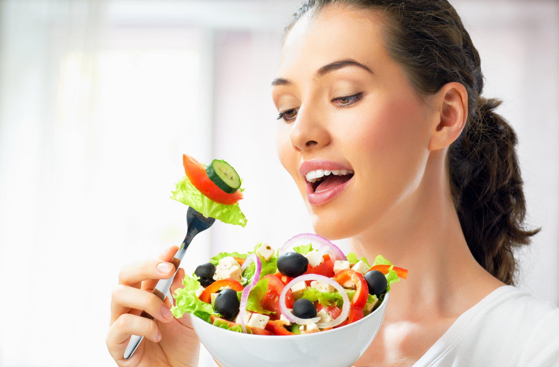 fille brune assiette fourchette salade légumes charme concombres olives oignon fromage tomates