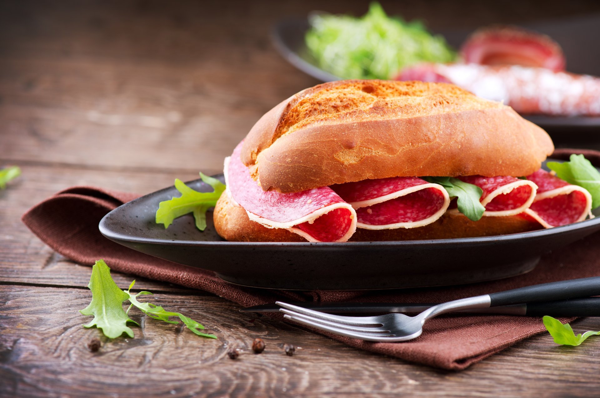 sandwich sandwich brötchen wurst salami mahlzeit teller gabel messer tisch