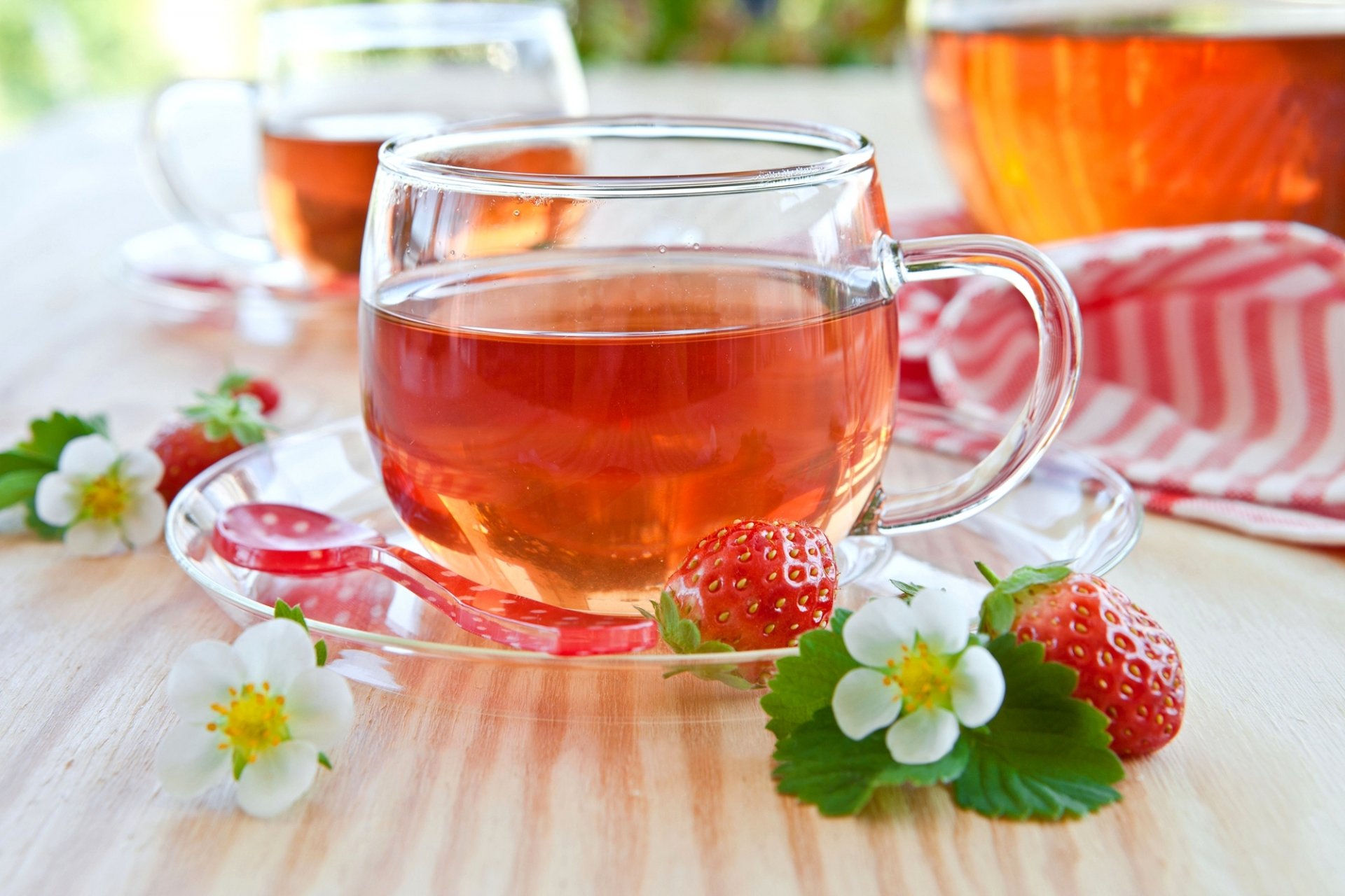 tee tasse untertasse geschirr löffel erdbeere erdbeere beeren rot blätter blumen weiß tisch