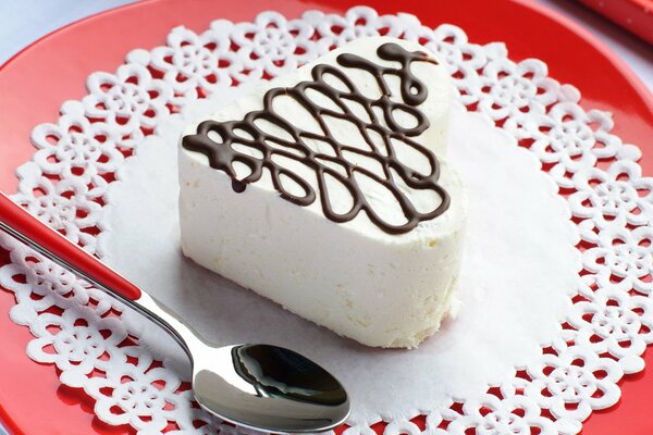 Cream cake with a chocolate mesh on an openwork napkin