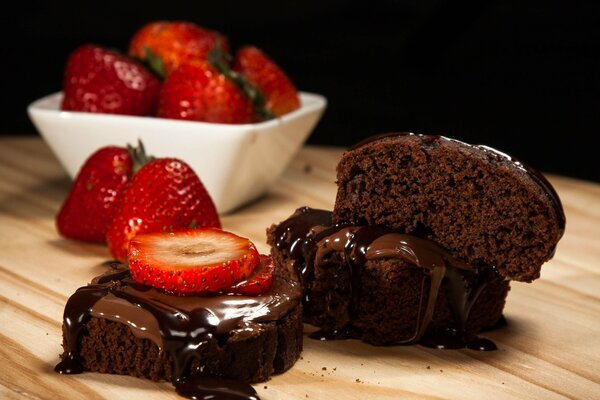 Chocolate dessert covered with chocolate and with strawberries next to it