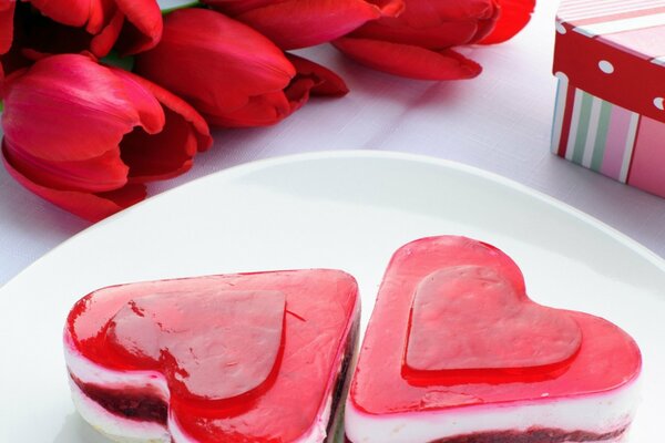 Postre en forma de corazón y tulipanes rojos