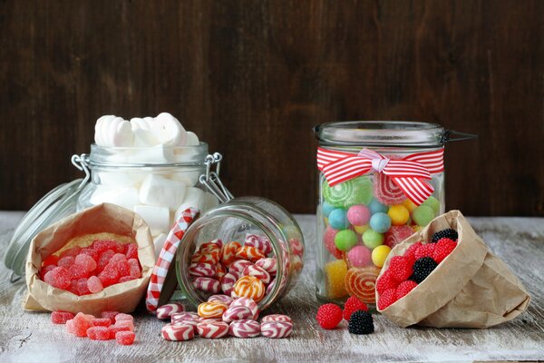 Candies and lollipops in jars on the table