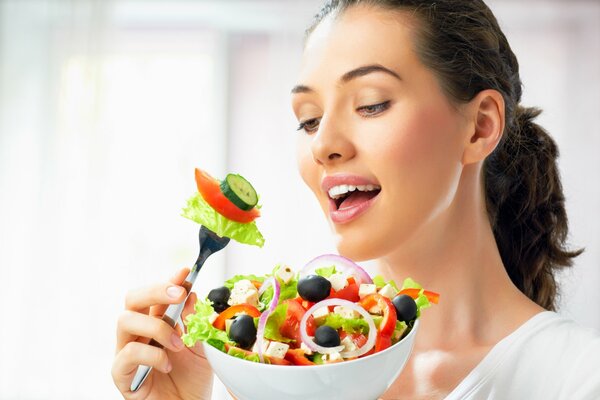 Adorable morena con plato de ensalada