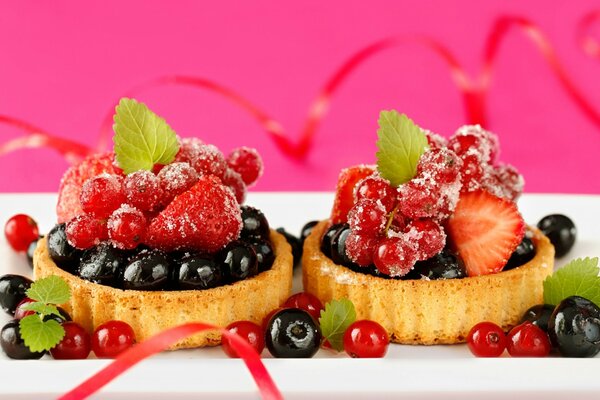 Cakes with blueberries and strawberries and mint leaves