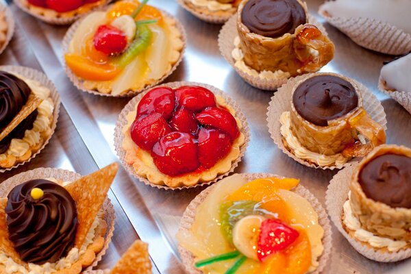 Gâteaux légers-paniers avec des garnitures de fruits et de baies