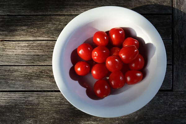 Rote Kirschtomaten in einem weißen Teller