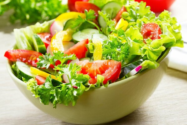 Salad of tomatoes cucumbers and herbs in a plate