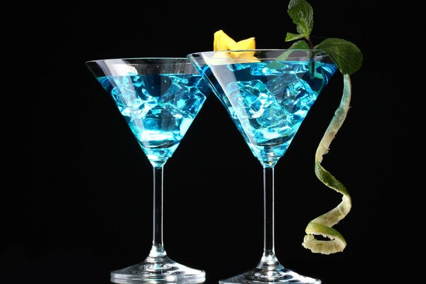 Carambola cocktails on a black background with ice and mint