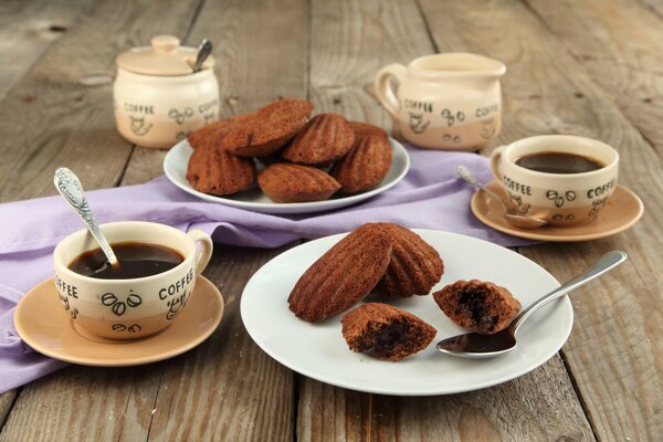 Café en tazas con galletas Madeleine