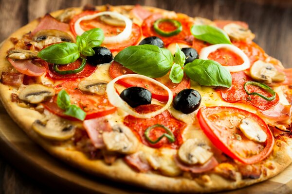 Pizza mit Schinken und Pilzen, Oliven sind beigefügt