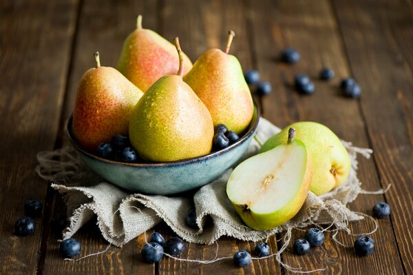 Natura morta con pere in una ciotola e mirtilli