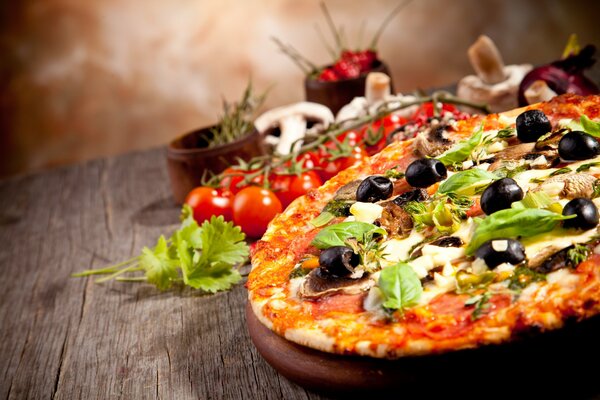 Pizza with olives on a wooden table