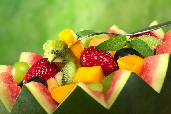 Obstsalat in geschnittene Wassermelone eingebettet