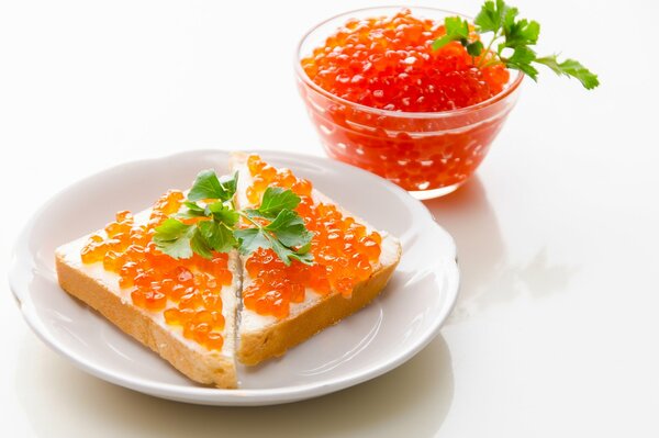 Sándwiches de caviar rojo en un plato blanco