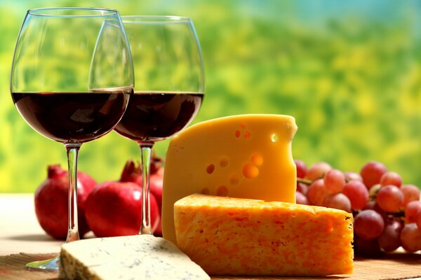 Stillleben von Käse und Wein auf einem saftigen grünen Hintergrund