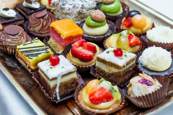 Assorted cakes with cream, chocolate, icing, fruits, berries, nuts, strawberries and kiwi