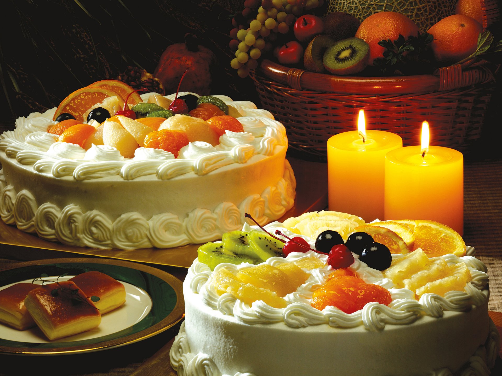 dessert cakes cream fruit slices kiwi oranges pineapple cherries cherries table candles basket grapes apples saucer puff