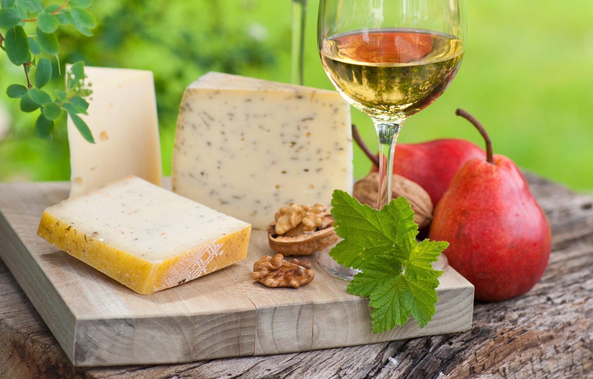 table planche verre vin blanc tranches poires noix verdure feuillage réflexion